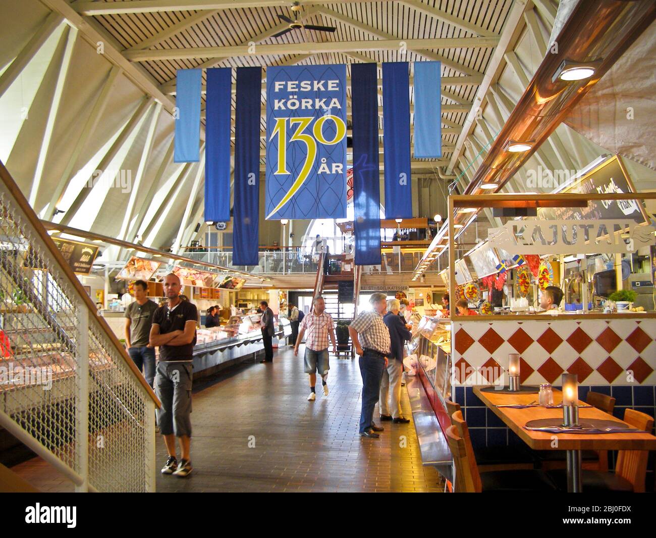 Interior of the 'Feske KÌ¦rka' (Fish Church), the main fish market in Gothenburg, Sweden, showing fish stalls and shoppers. - Stock Photo