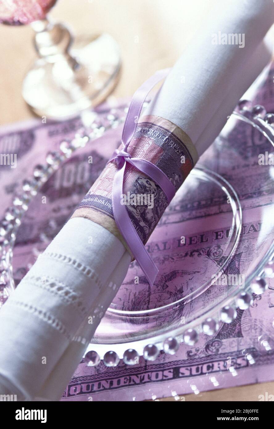 Napkin ring and place mat made from old foreign bank notes - Stock Photo
