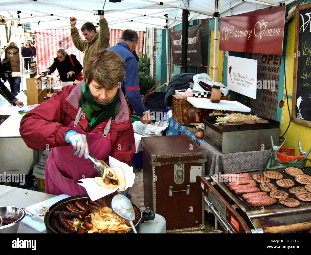 Serving venison sausages at Whitecross street market, London EC1 - Stock Photo