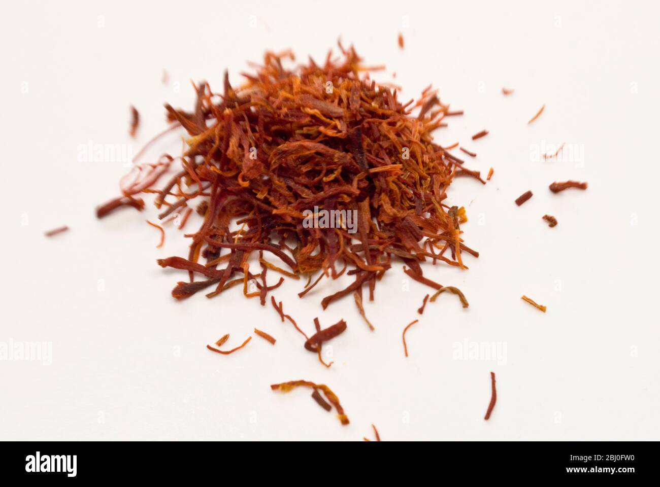 Strands of saffron on white surface Stock Photo Alamy