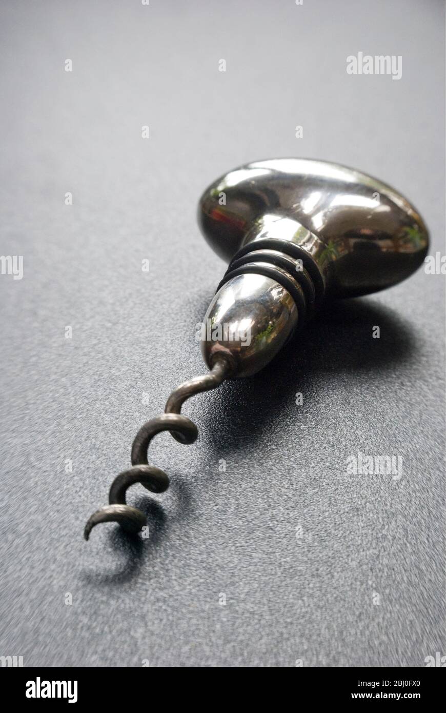 Silver plated corkscrew which doubles as a stopper - Stock Photo