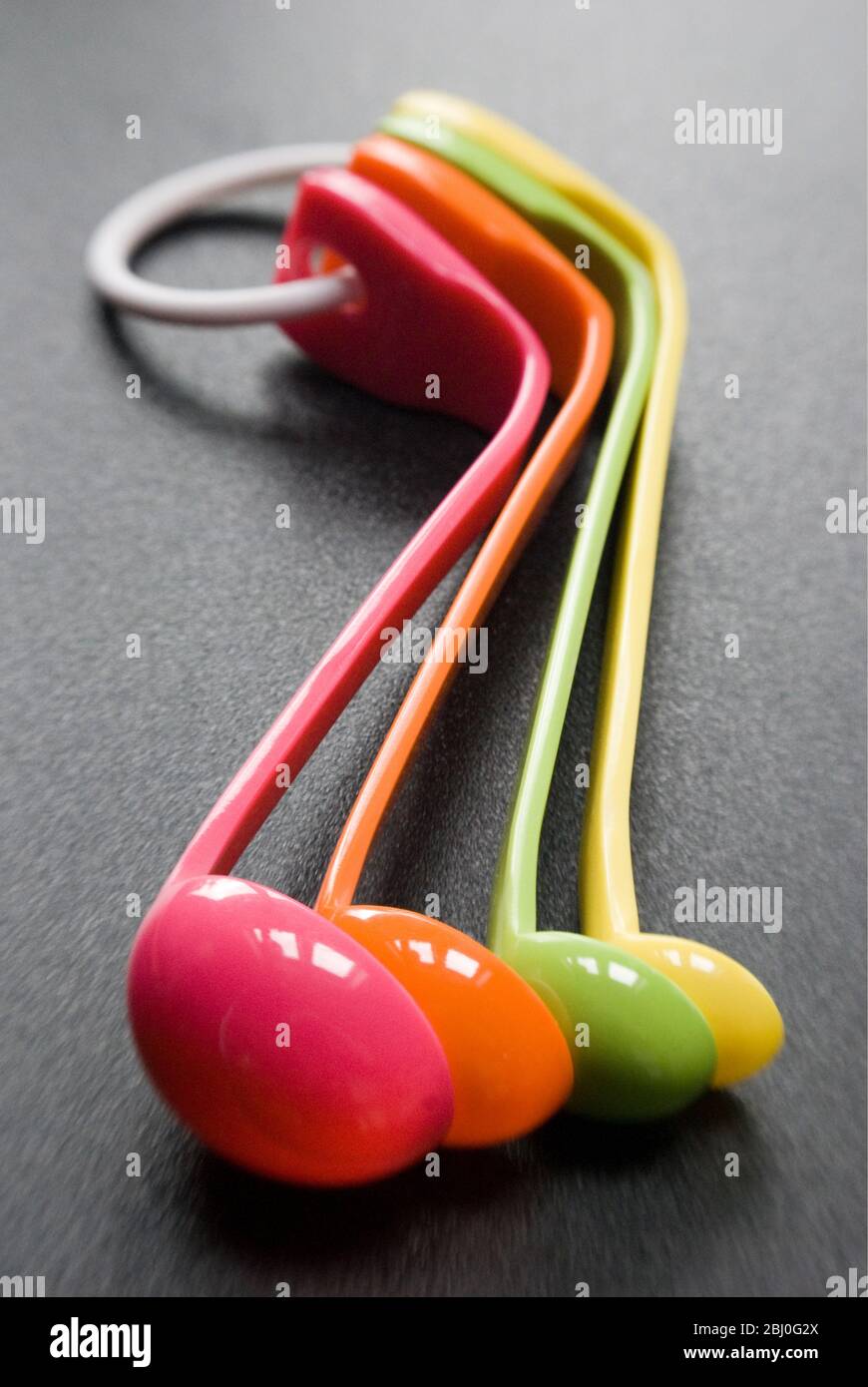 Set of brightly coloured melamine plastic measuring spoons - Stock Photo