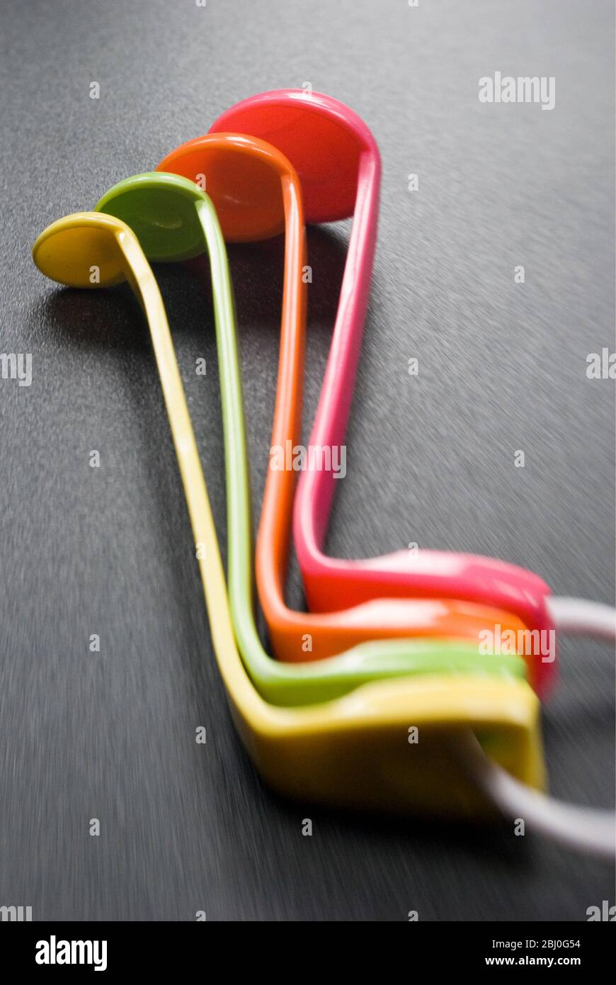 Set of brightly coloured melamine plastic measuring spoons Stock Photo