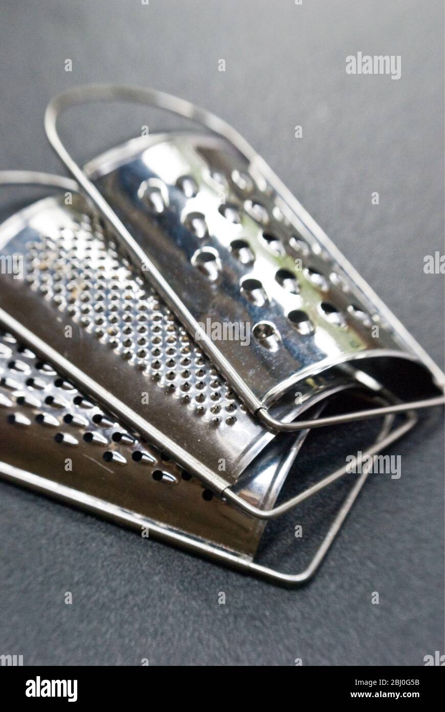Set of three small graters, with different size holes - Stock Photo
