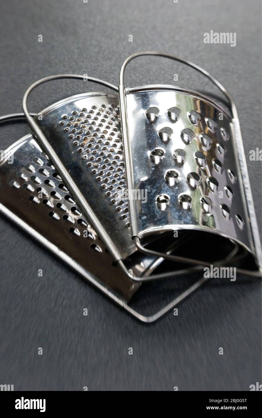Set of three small graters, with different size holes - Stock Photo