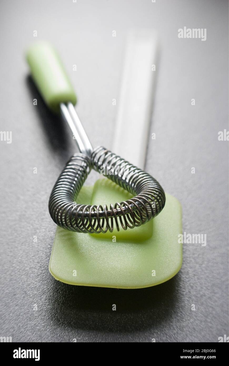 Cookery equipment,, wire whisk and green plastic and silicone spatula - Stock Photo
