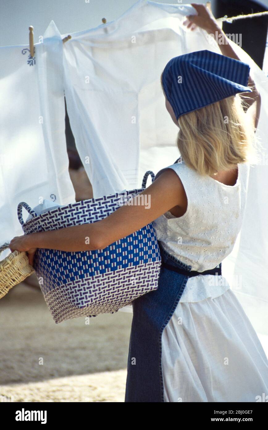 Hanging out the laundry on washing line in sunshine with a breeze - Stock Photo