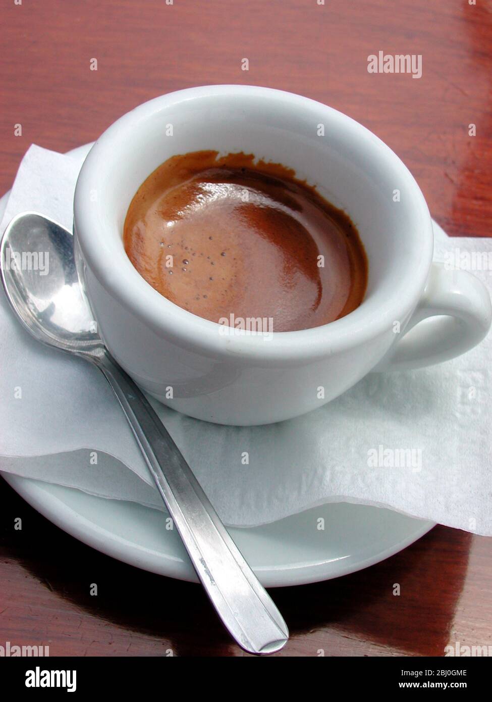 Small cup of strong espresso coffee, served in outdoor cafe in Amalfi, Italy - Stock Photo