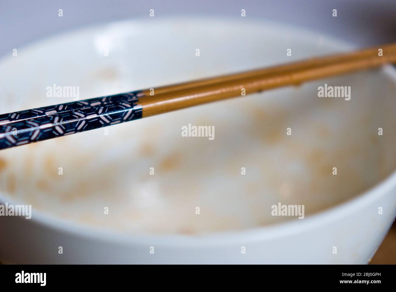 Empty rice bowl with Japanese decorated chopsticks - Stock Photo