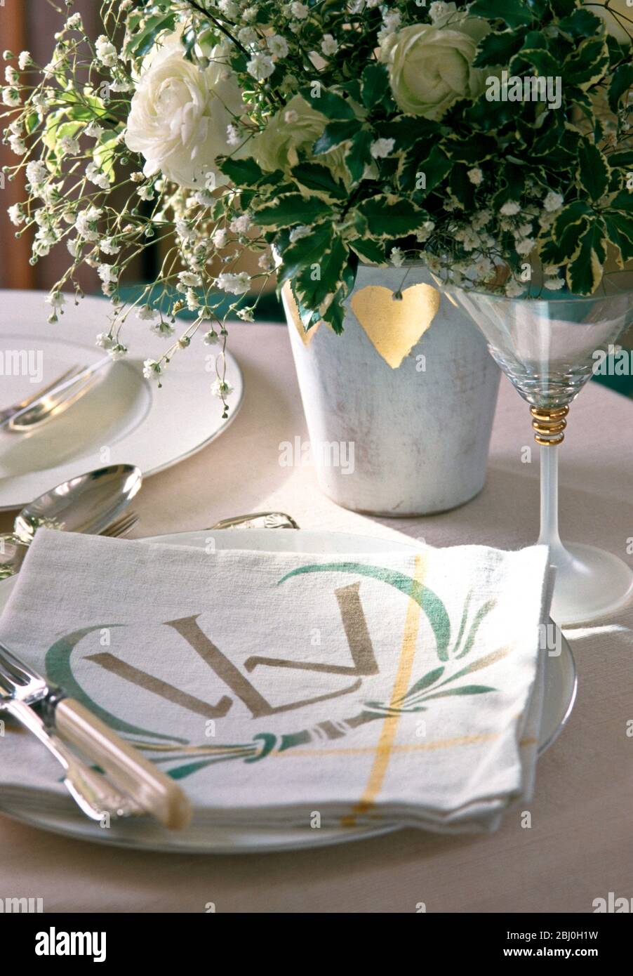 Specially stencilled napkins as part of table setting for wedding reception - Stock Photo