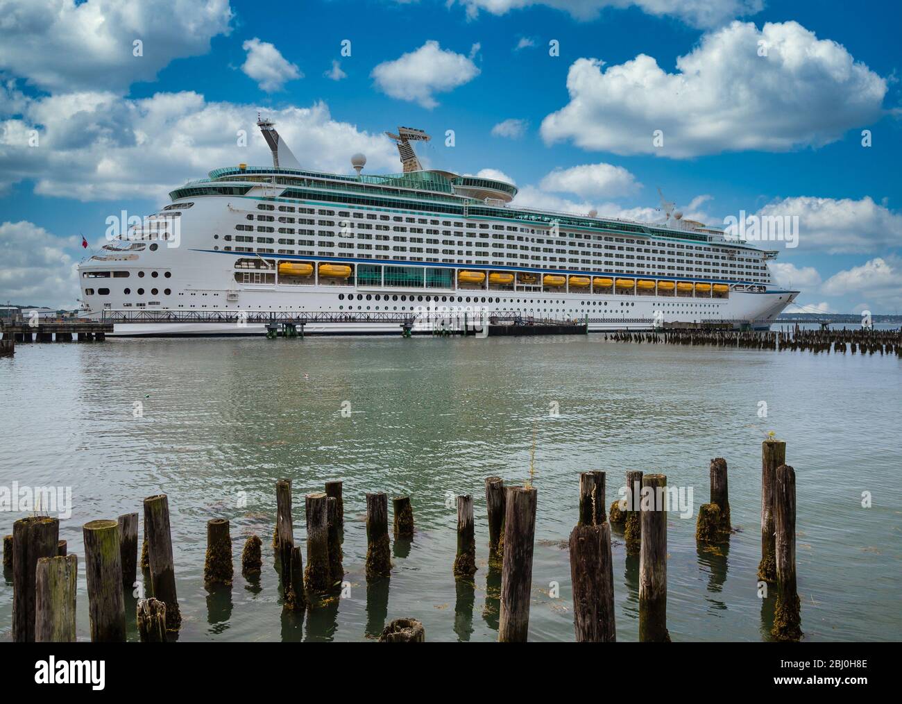Luxury Cruise Ship Beyond Wood Pilings Stock Photo