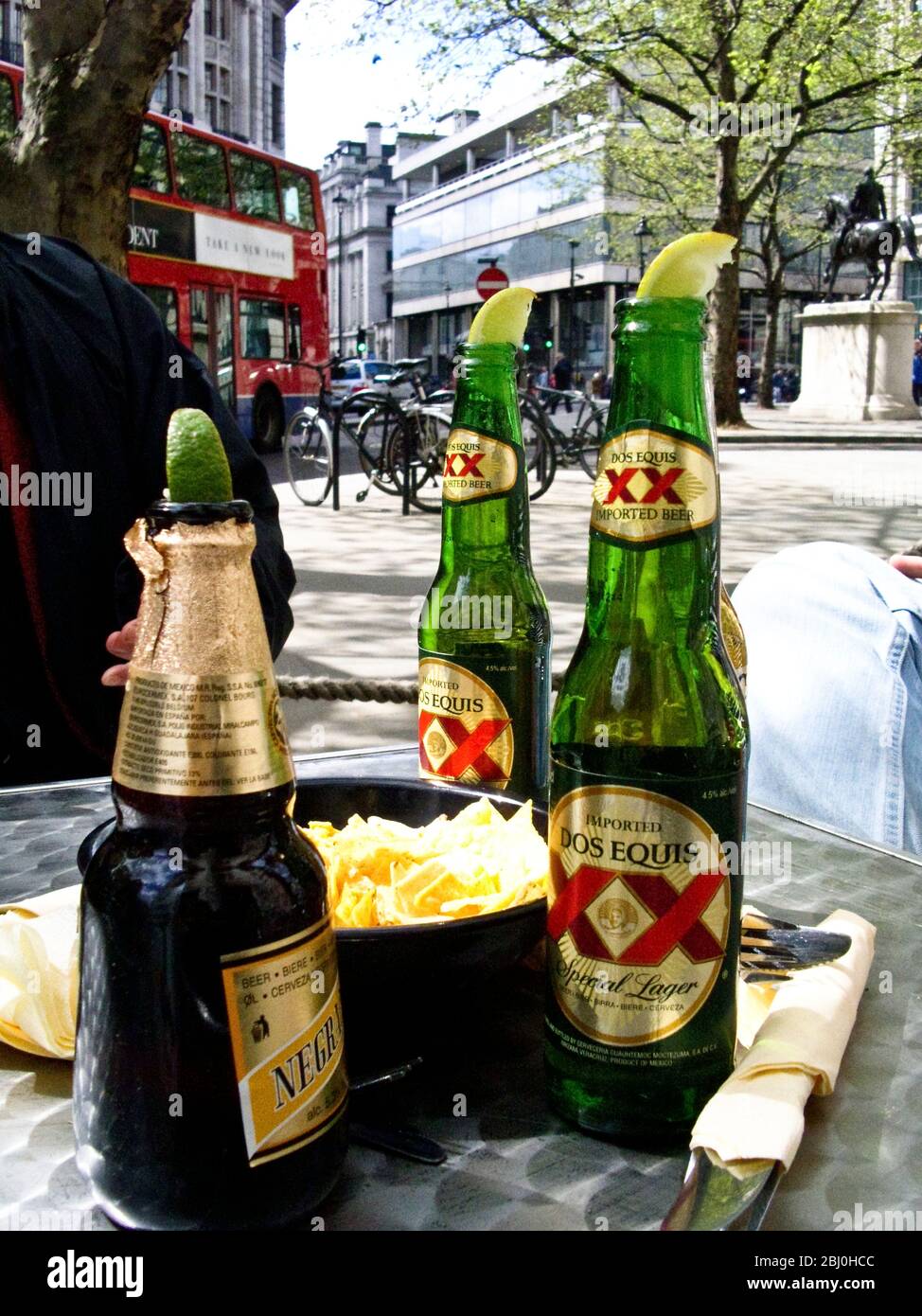 Mexican beers in spring sunshine outside cafe by London's Trafalgar Square - Stock Photo