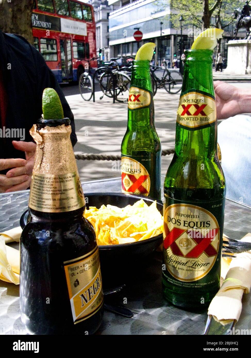 Mexican beers in spring sunshine outside cafe by London's Trafalgar Square - Stock Photo