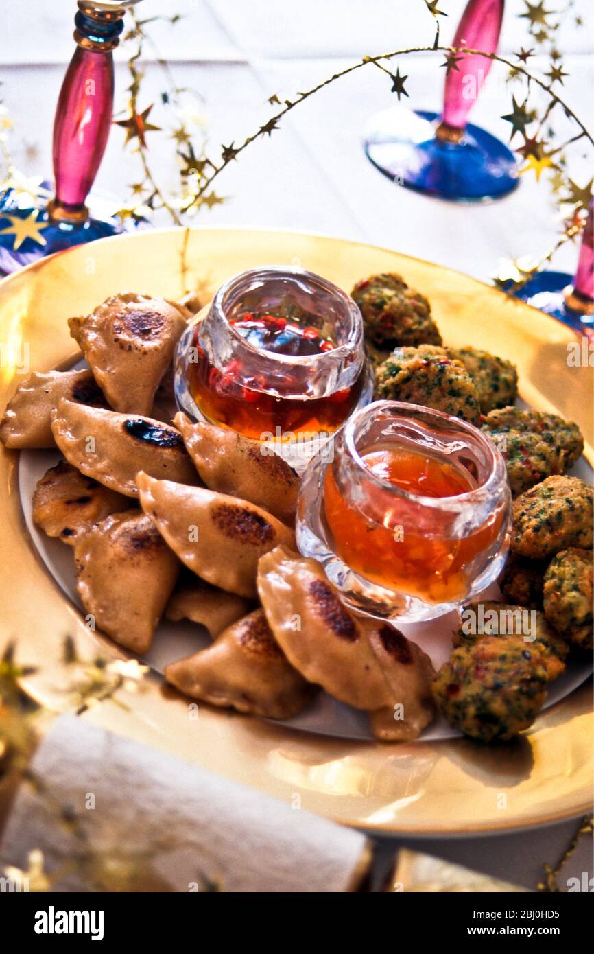 Indian snacks as party canapes with sweet hot sauce - Stock Photo