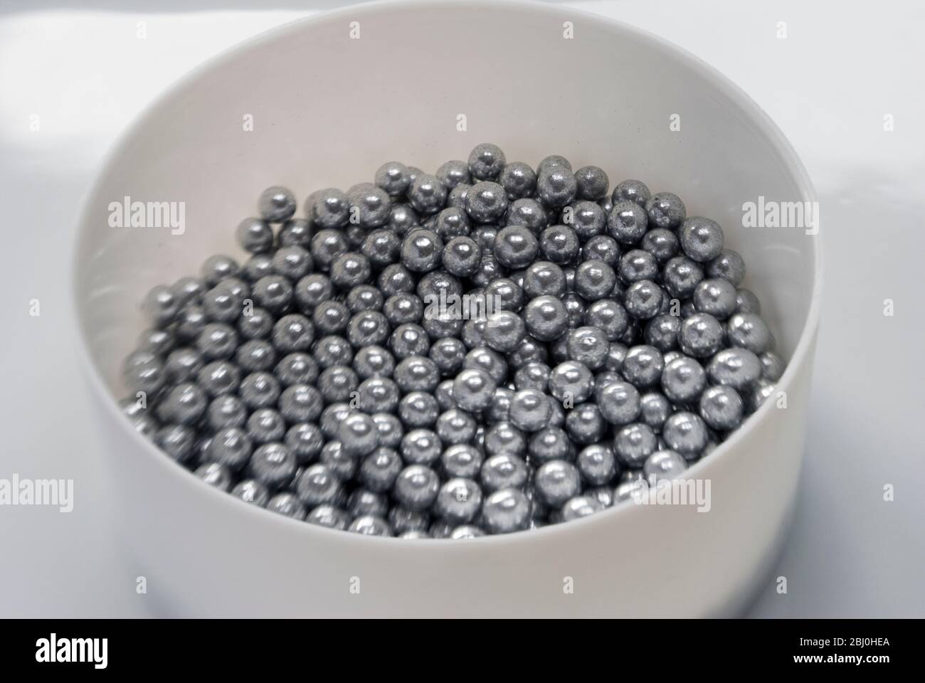 Edible silver balls for cake decorating, Shot with Lensbaby lens for blurred edge effect - Stock Photo