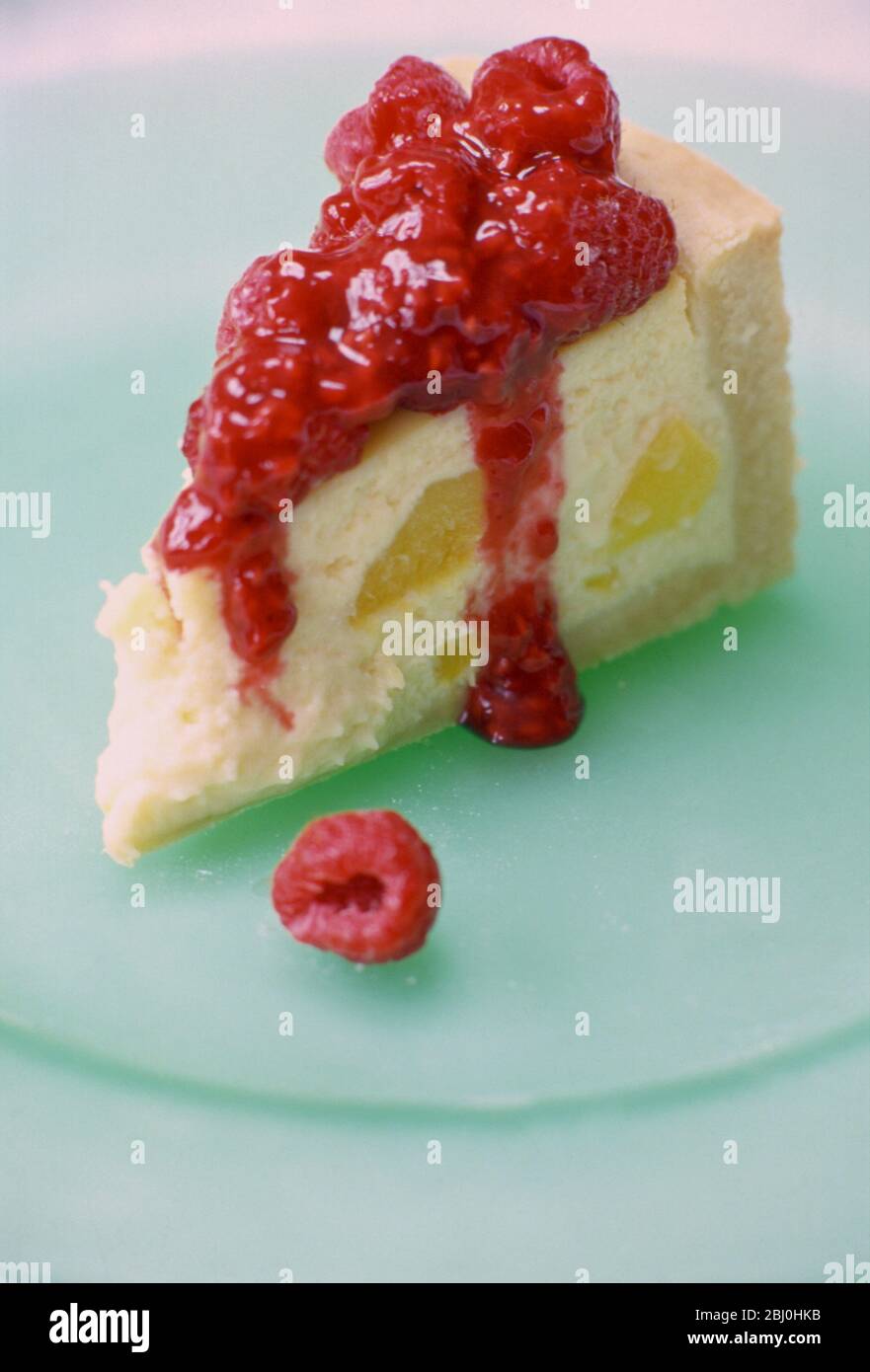 Baked cheesecake topped with raspberries and puree - Stock Photo