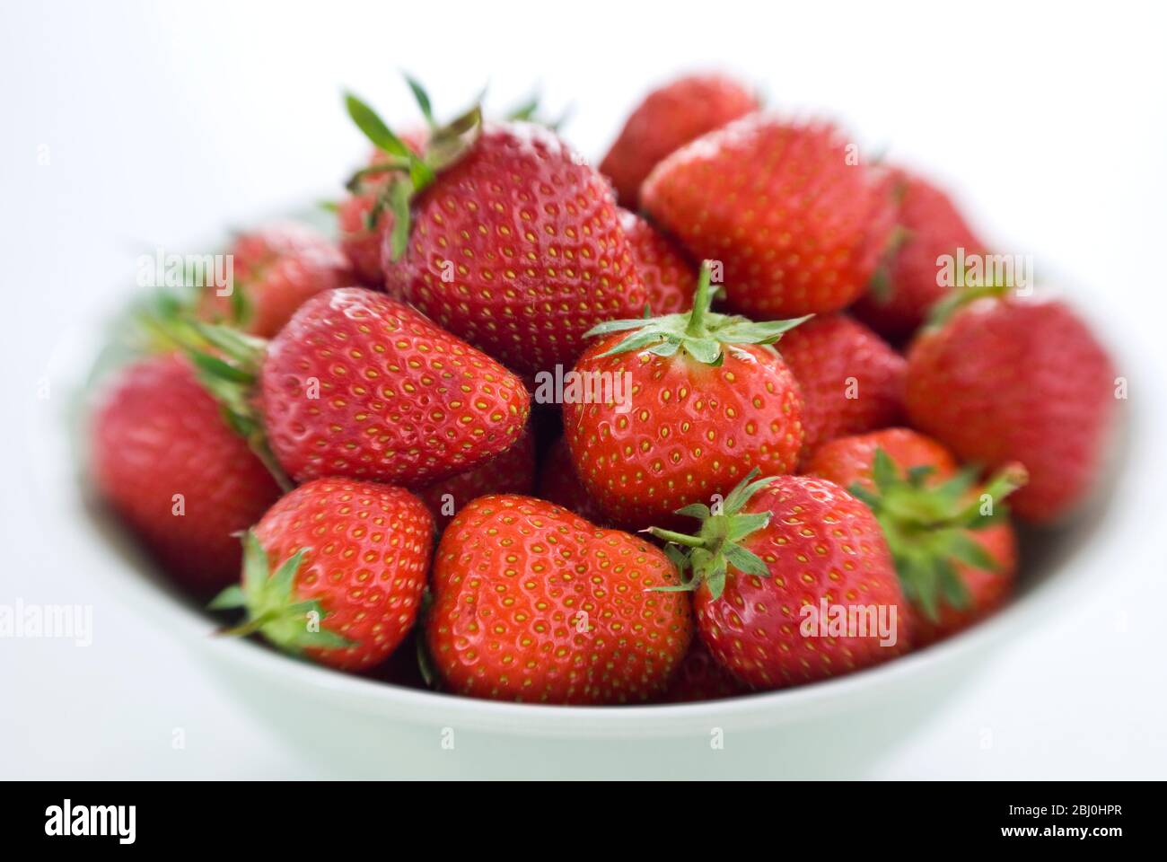 Bowl full of ripe red strawberries, shot on Lensbaby lens for blurred edge effect. - Stock Photo