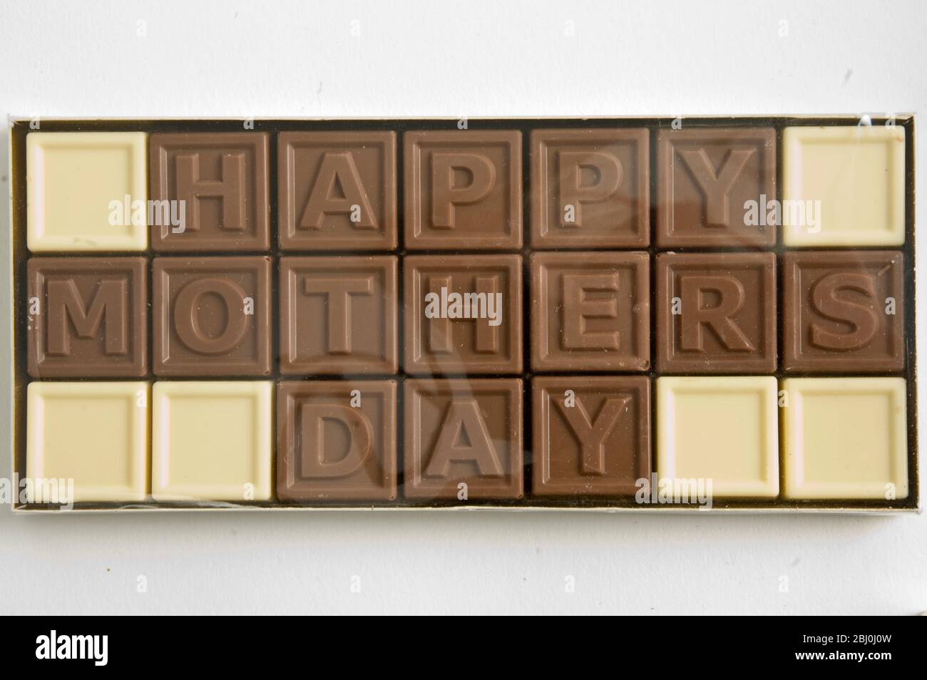 Chocolate letters spelling 'Happy Mother's Day' in cellophane box as Mother's day gift - Stock Photo