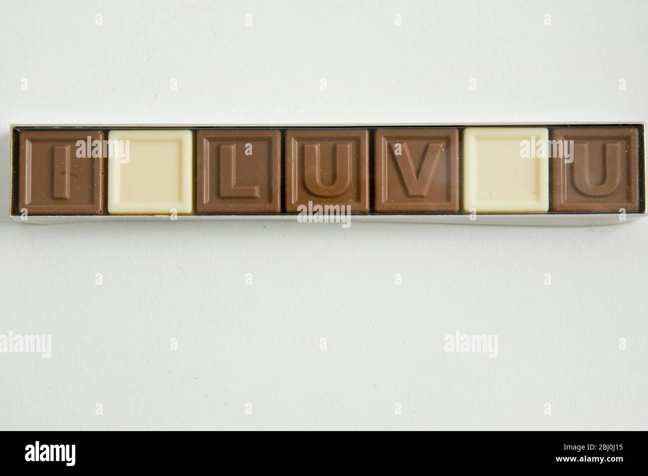 Chocolate letters spelling 'I LOVE YOU' in cellophane box as Valentine's day gift - Stock Photo