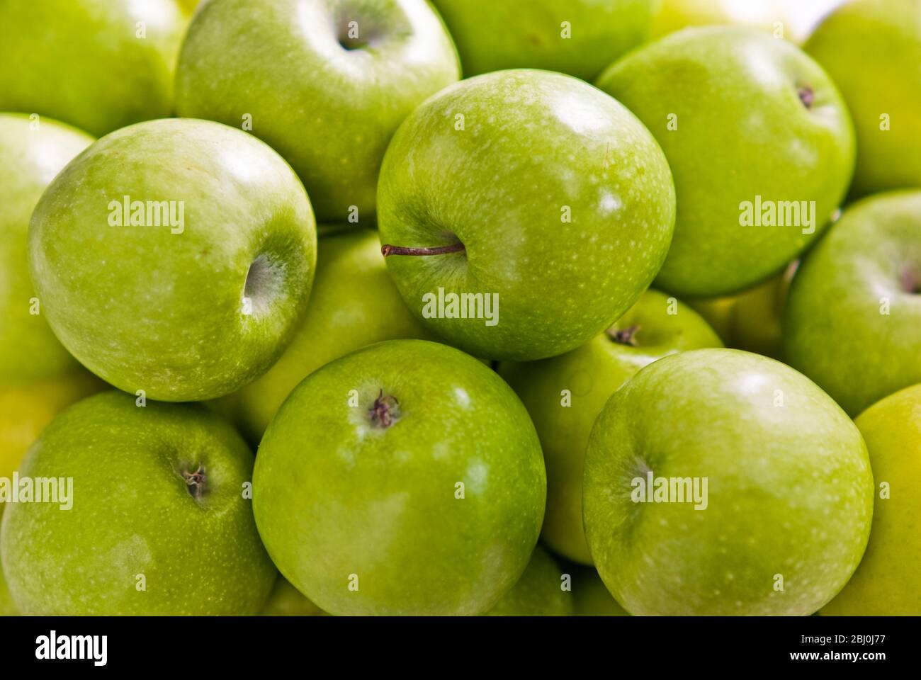 Massed green Granny Smith apples against white background - Stock Photo
