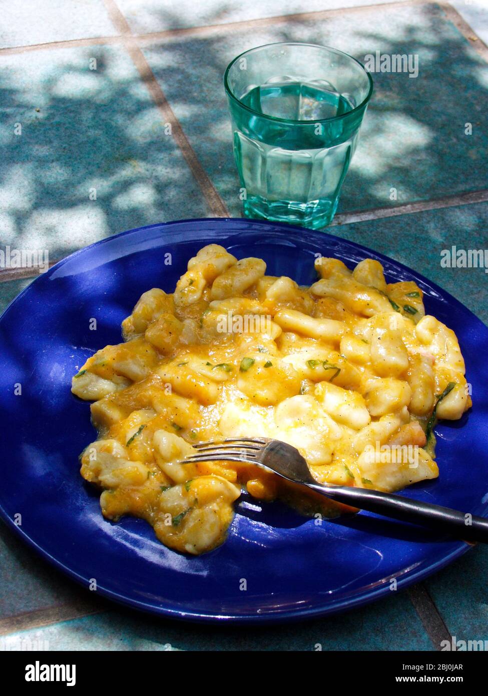 Gnocchi with pumpkin sauce served outdoors - Stock Photo