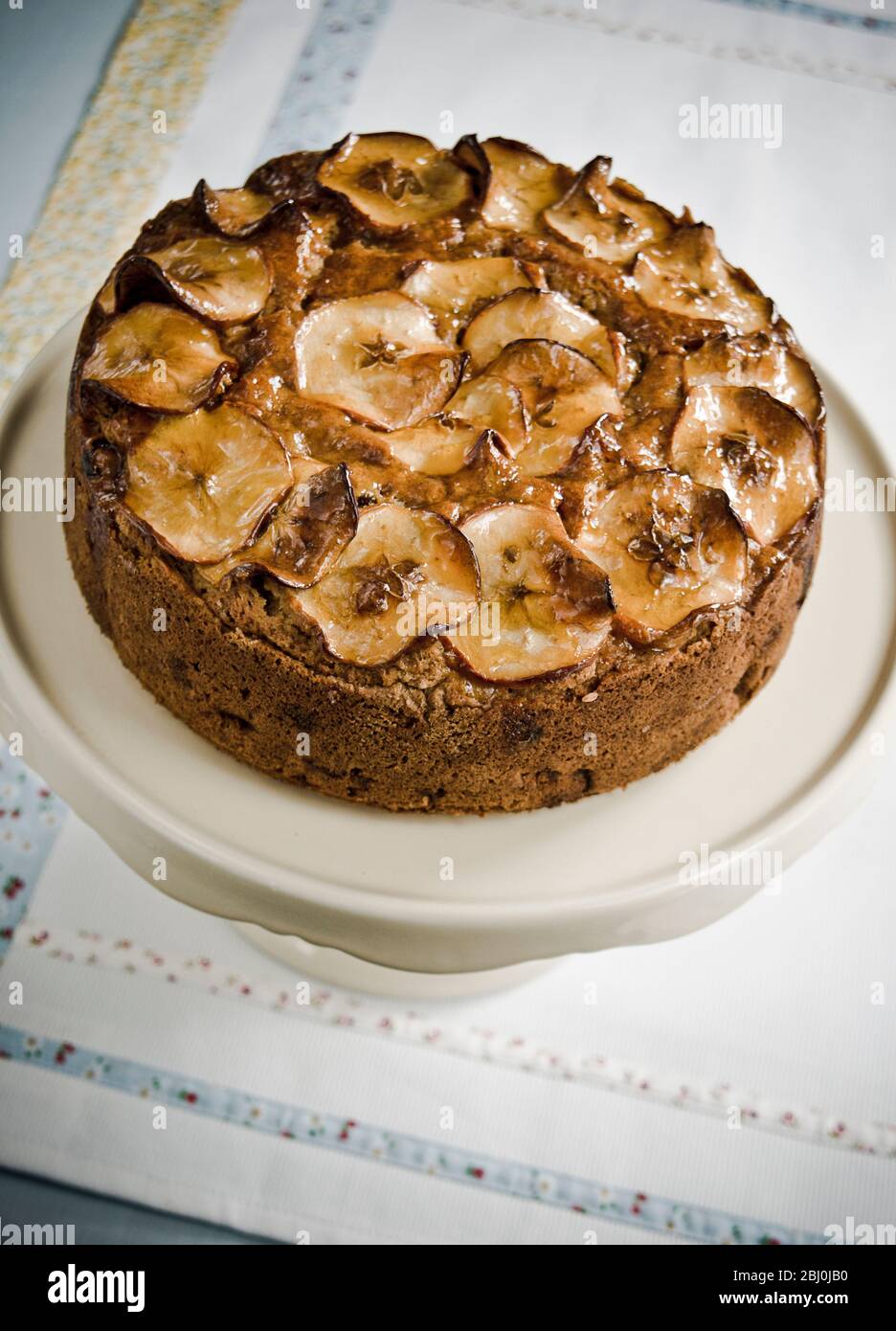 Apple fruit cake with cider and topping of glazed apple slices - Stock Photo