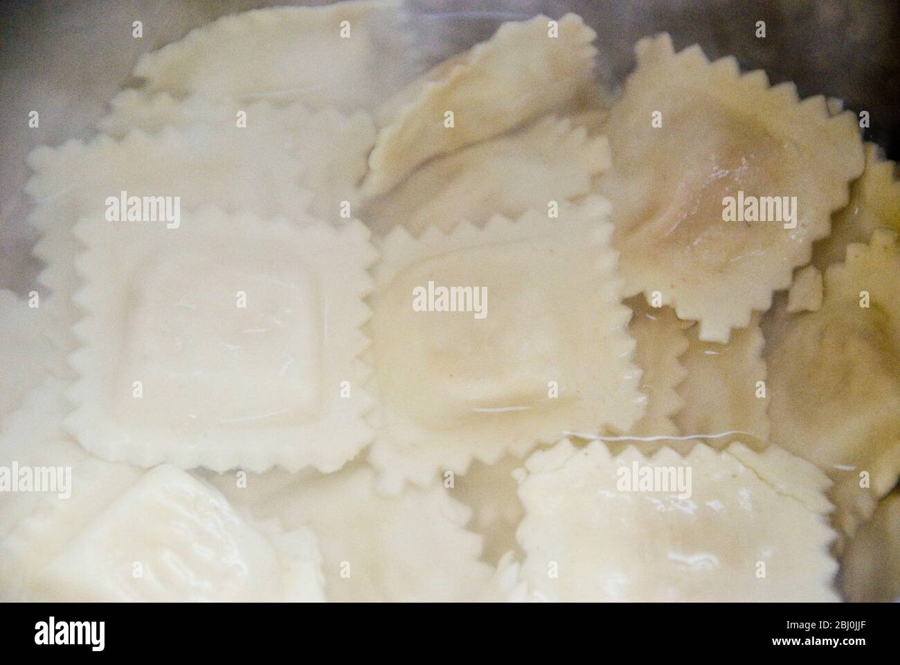 Ravioli being cooked in boiling water in stainless steel pan Stock Photo