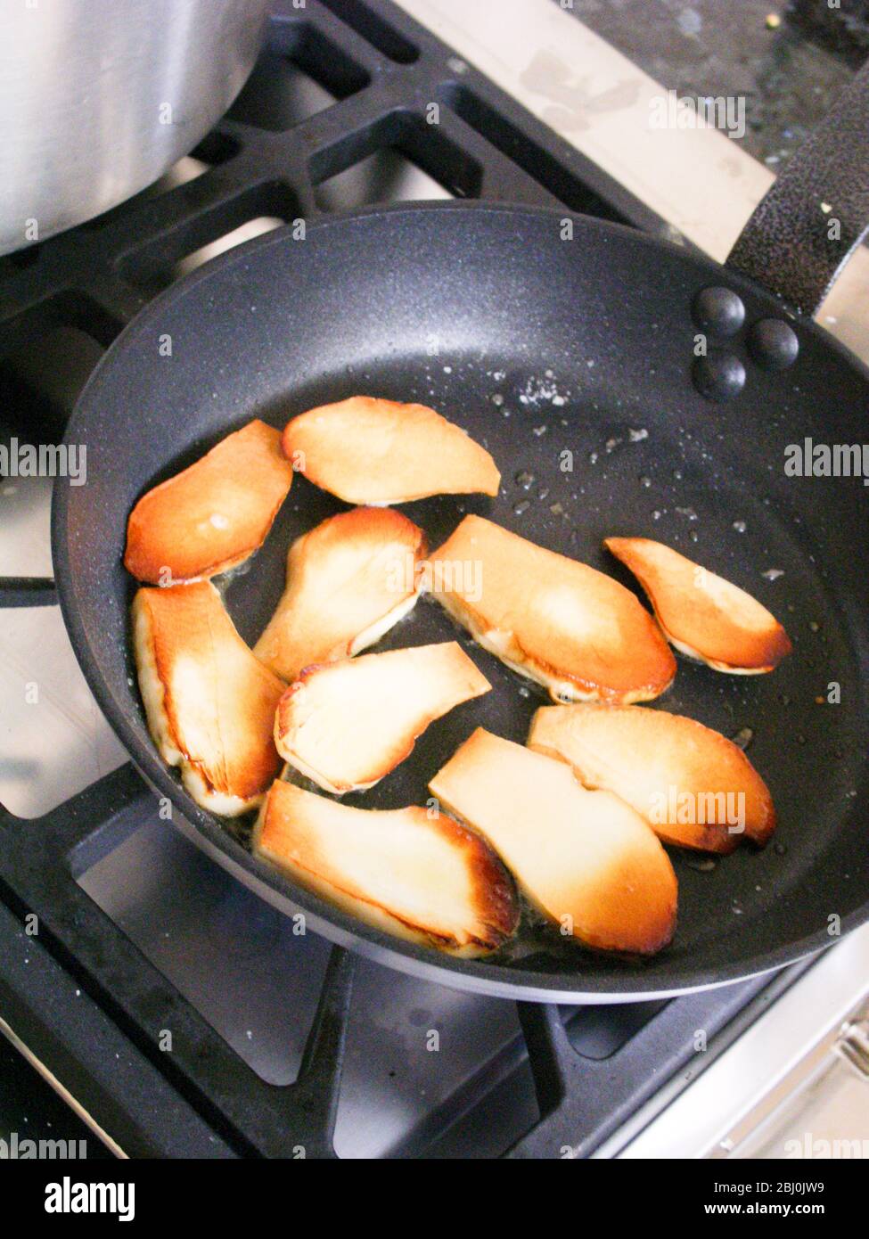 Slices of ceps quickly fried in hot olive oil. - Stock Photo