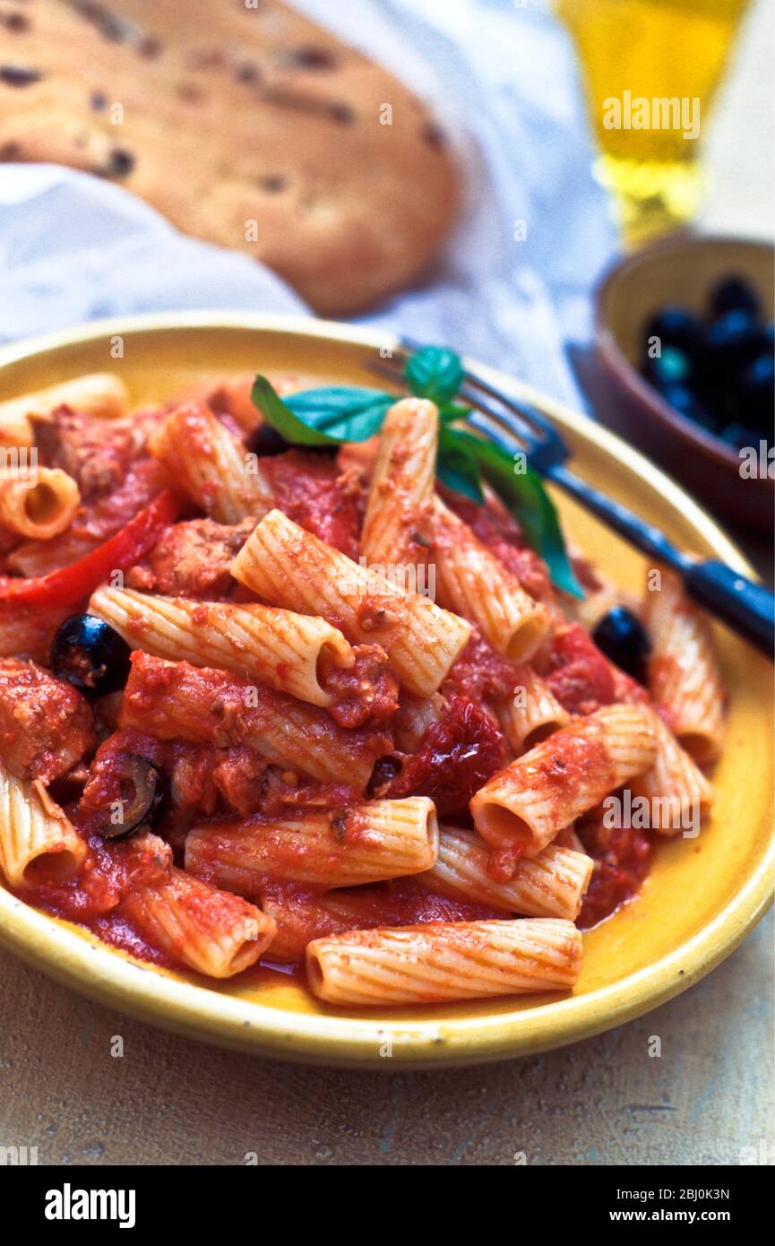 Rigatoni pasta shapes, tomato tuna and black olive sauce - Stock Photo