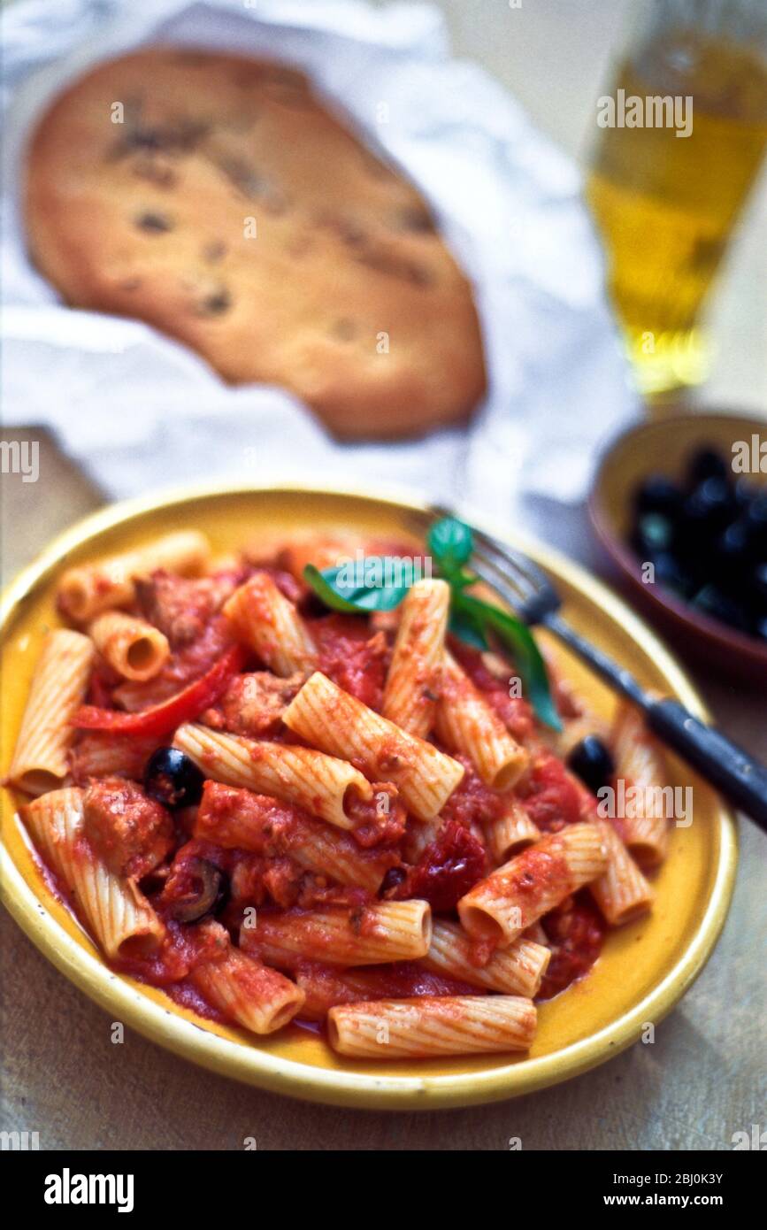 Rigatoni pasta shapes, tomato tuna and black olive sauce - Stock Photo