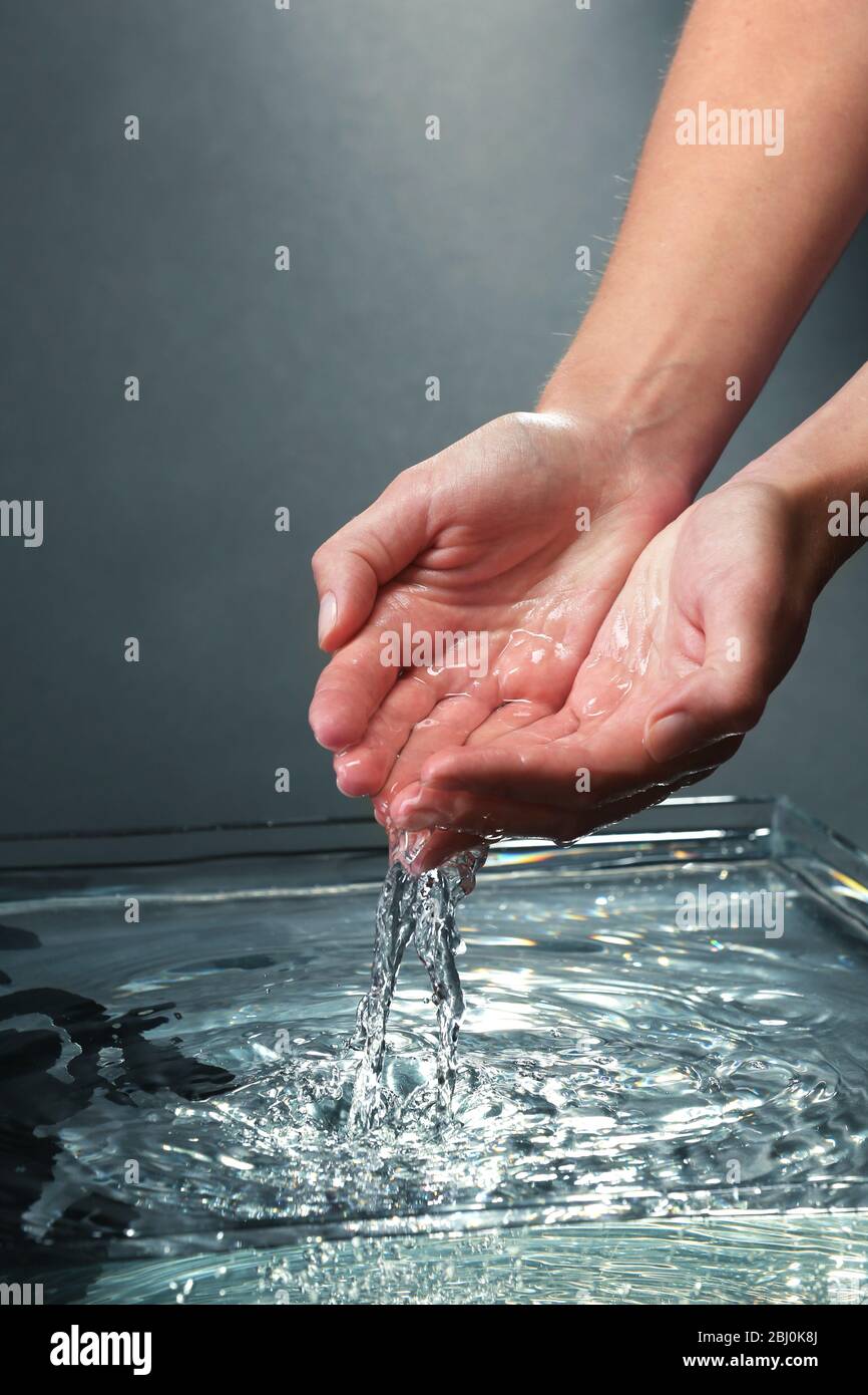 Female hands with water splashing on dark background Stock Photo - Alamy