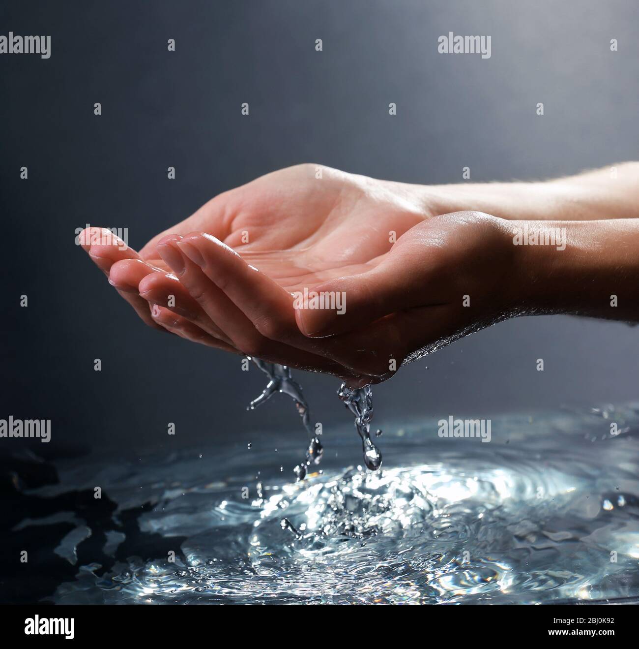 Female hands with water splashing on dark background Stock Photo - Alamy