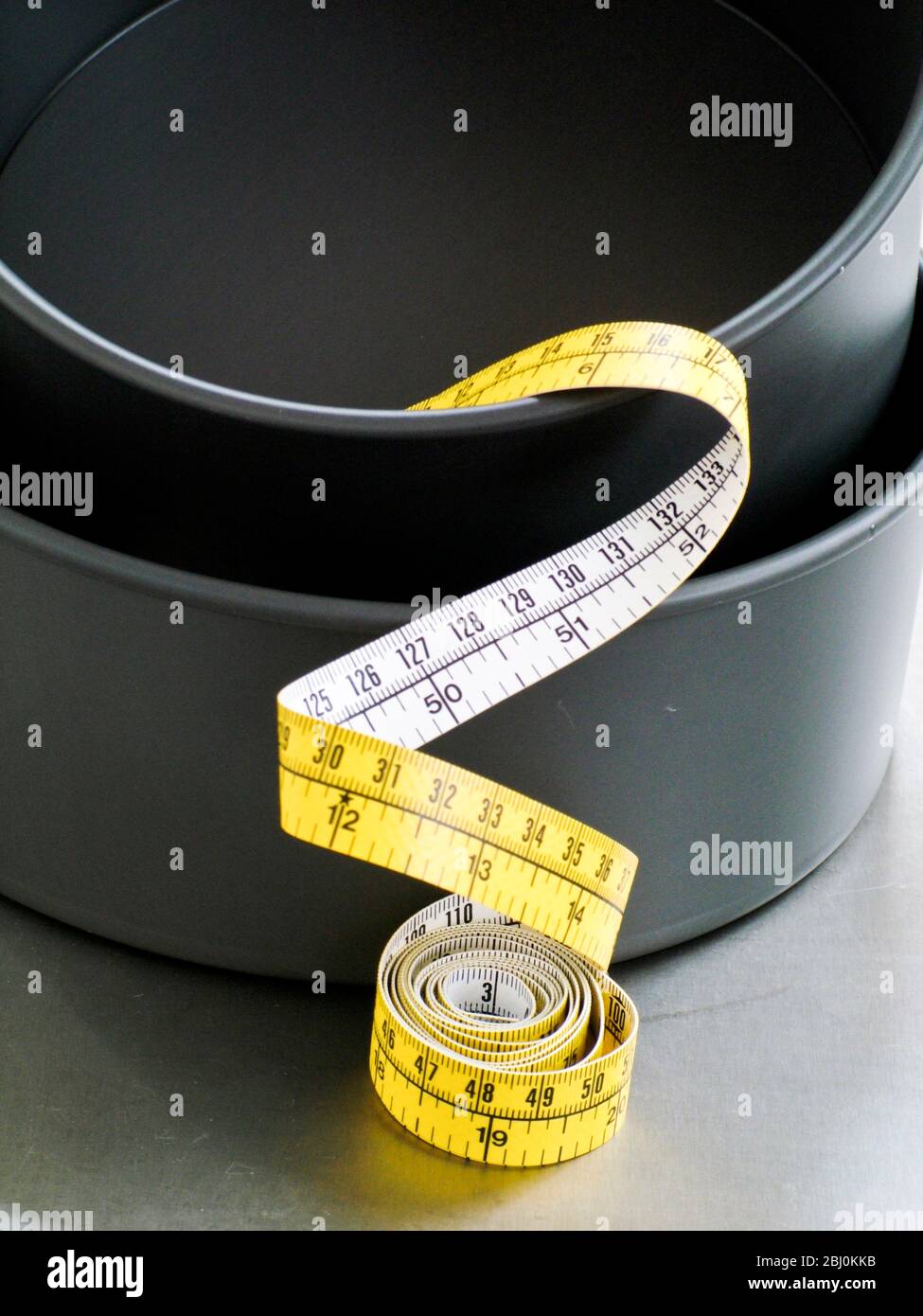 Cake tins and tape measure - Stock Photo