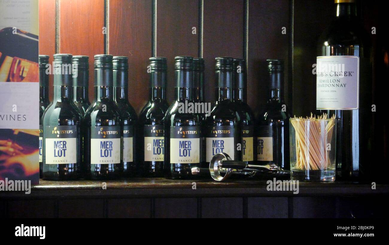 Red wine in small individual bottles on shelf of rural pub in Wrotham, Kent, UK - Stock Photo