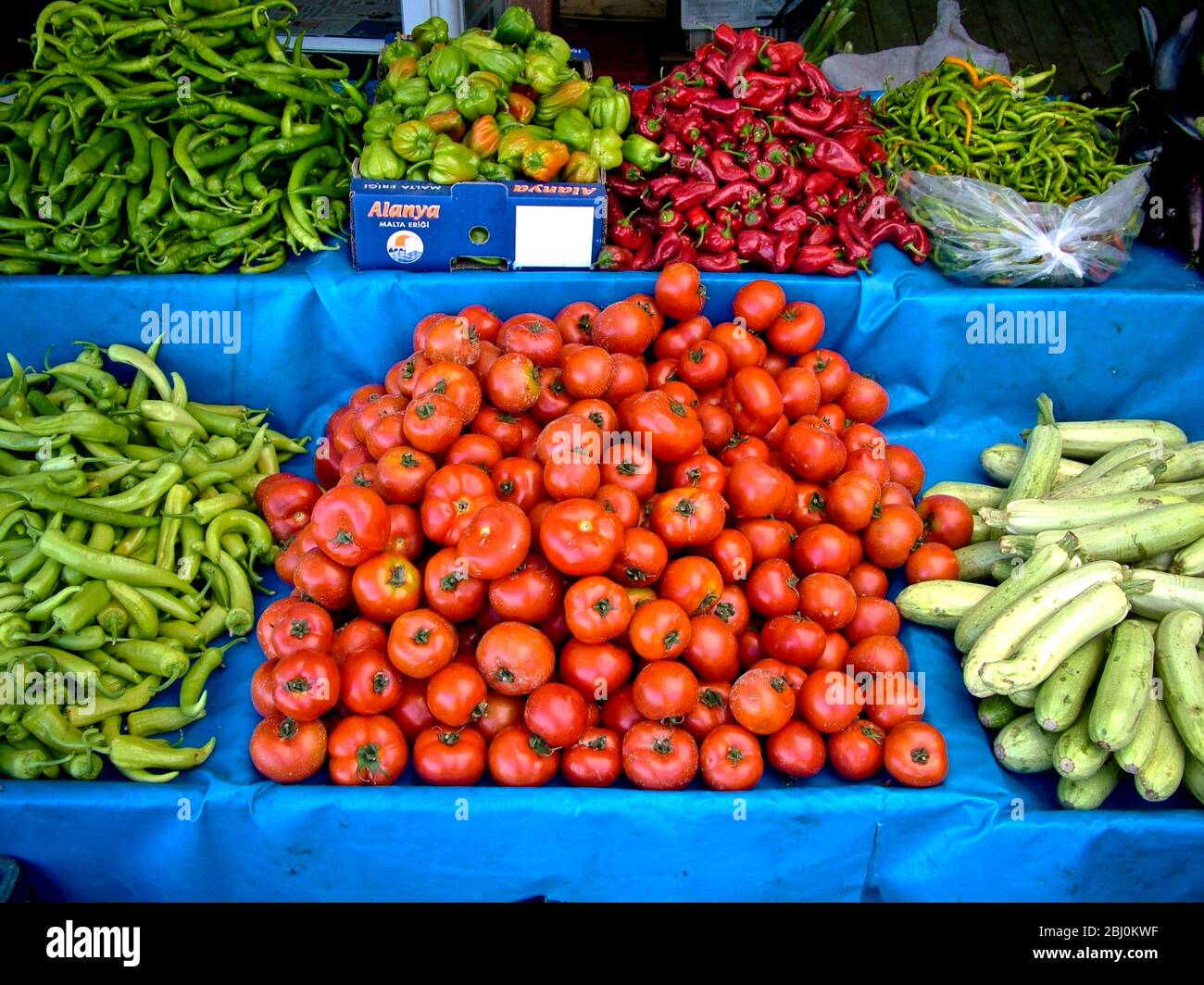 Selection of fresh vegetables - tomatoes, cucumbers and several varieties of peppers on market stall outside shop in Dalayan, Anatolia, southern Turke Stock Photo