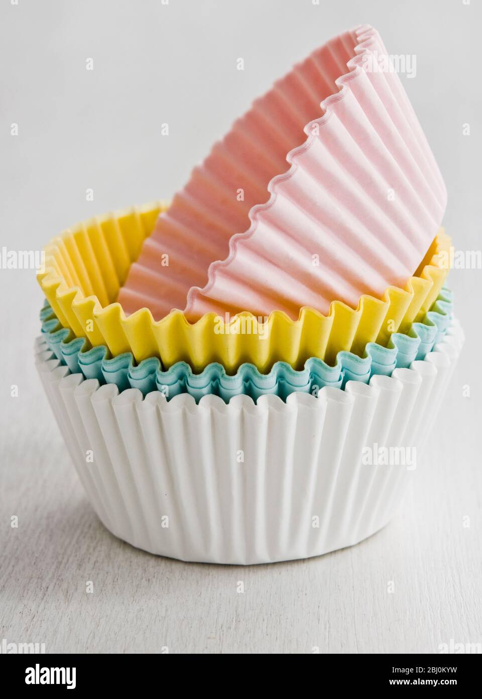 Stack of coloured paper cake and muffin cases - Stock Photo