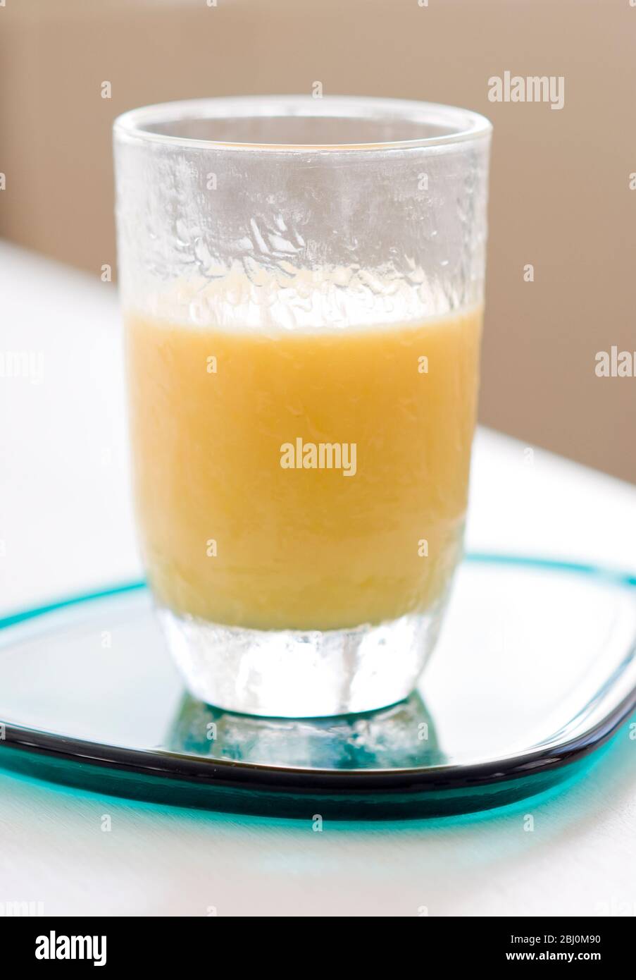 Frosted glass of mango and orange smoothie - Stock Photo