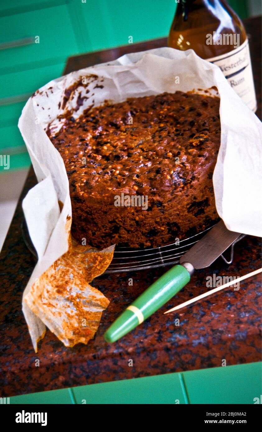 Homemade Christmas cake, being unwrapped from its greaseproof paper. - Stock Photo