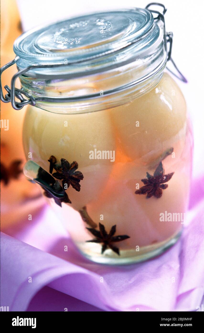 Whole peeled pears bottled in syrp flavoured with star anise, as edible gift - Stock Photo
