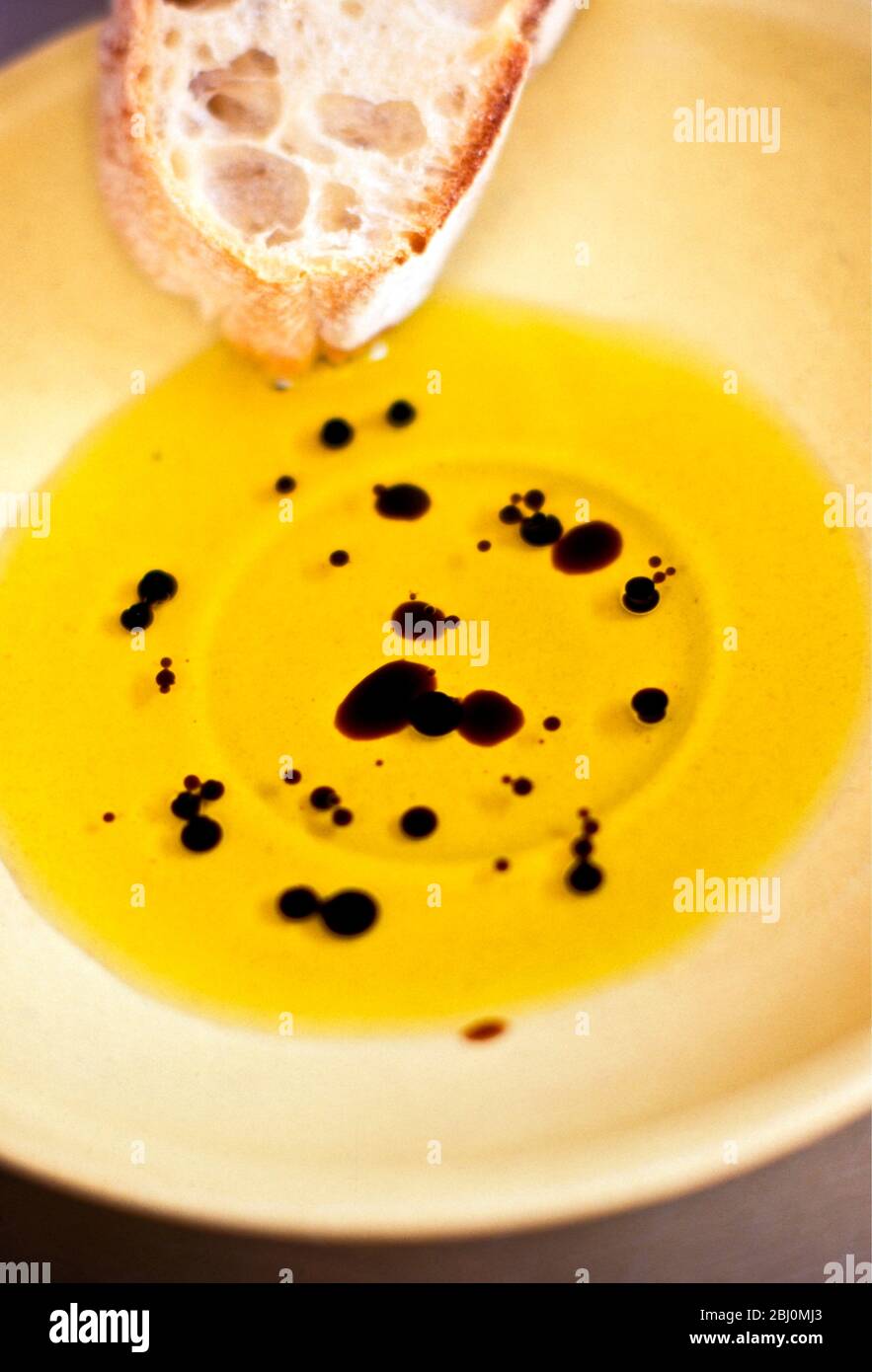Olive oil with balsamic vinegar in yellow pottery dish with ciabatta