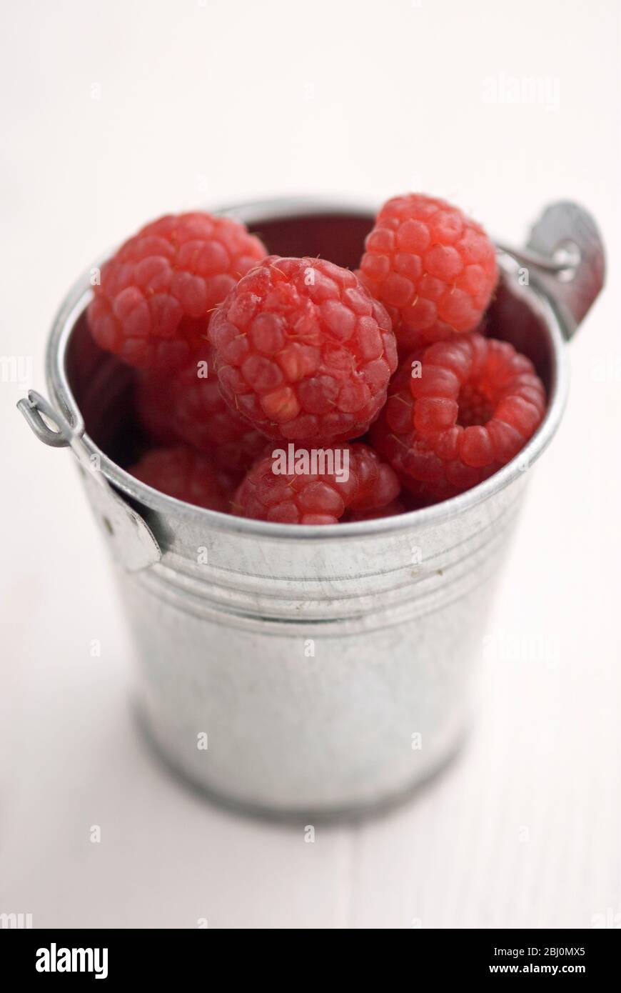 Miniature metal bucket with fresh raspberries - Stock Photo