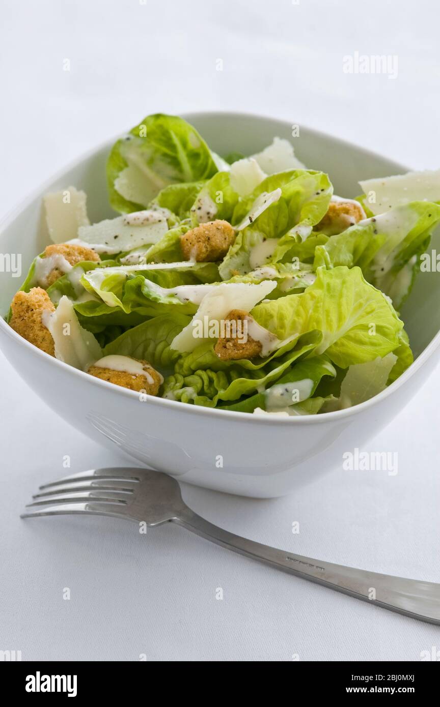 Classic caesar salad in white bowl - Stock Photo