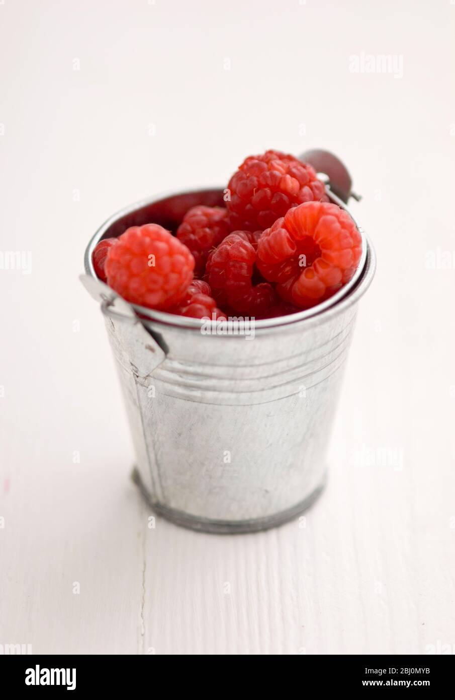 Miniature metal bucket with fresh raspberries - Stock Photo