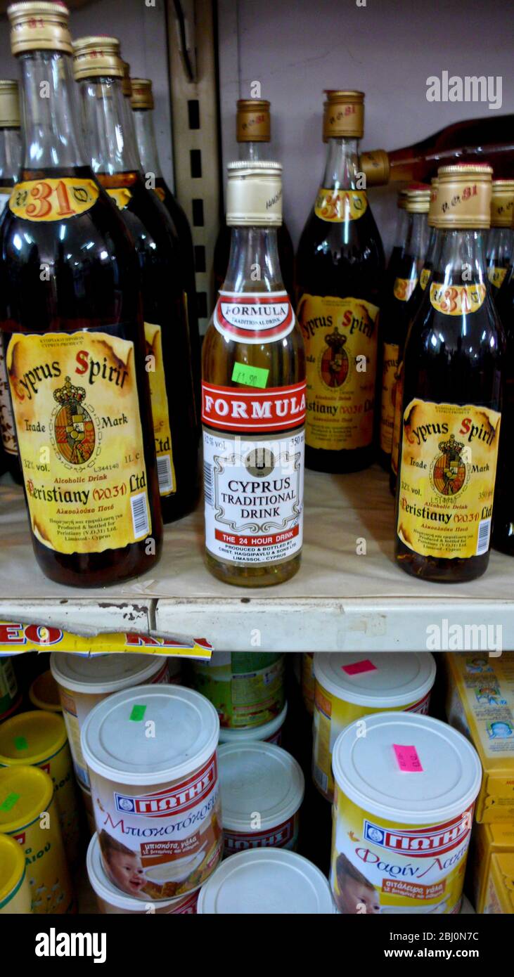 Shelf in Cyprus supermarket showing selection of local spirits in bottles labelled in English - Stock Photo