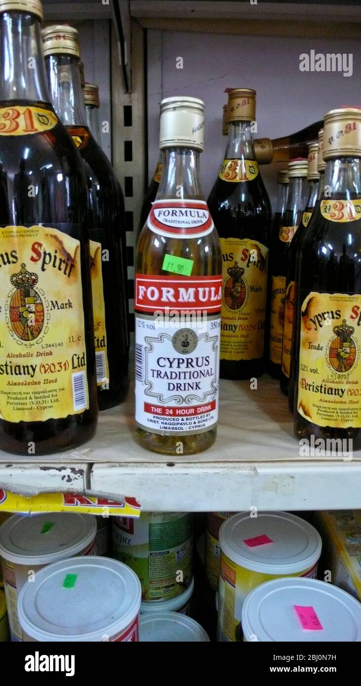Shelf in Cyprus supermarket showing selection of local spirits in bottles labelled in English - Stock Photo