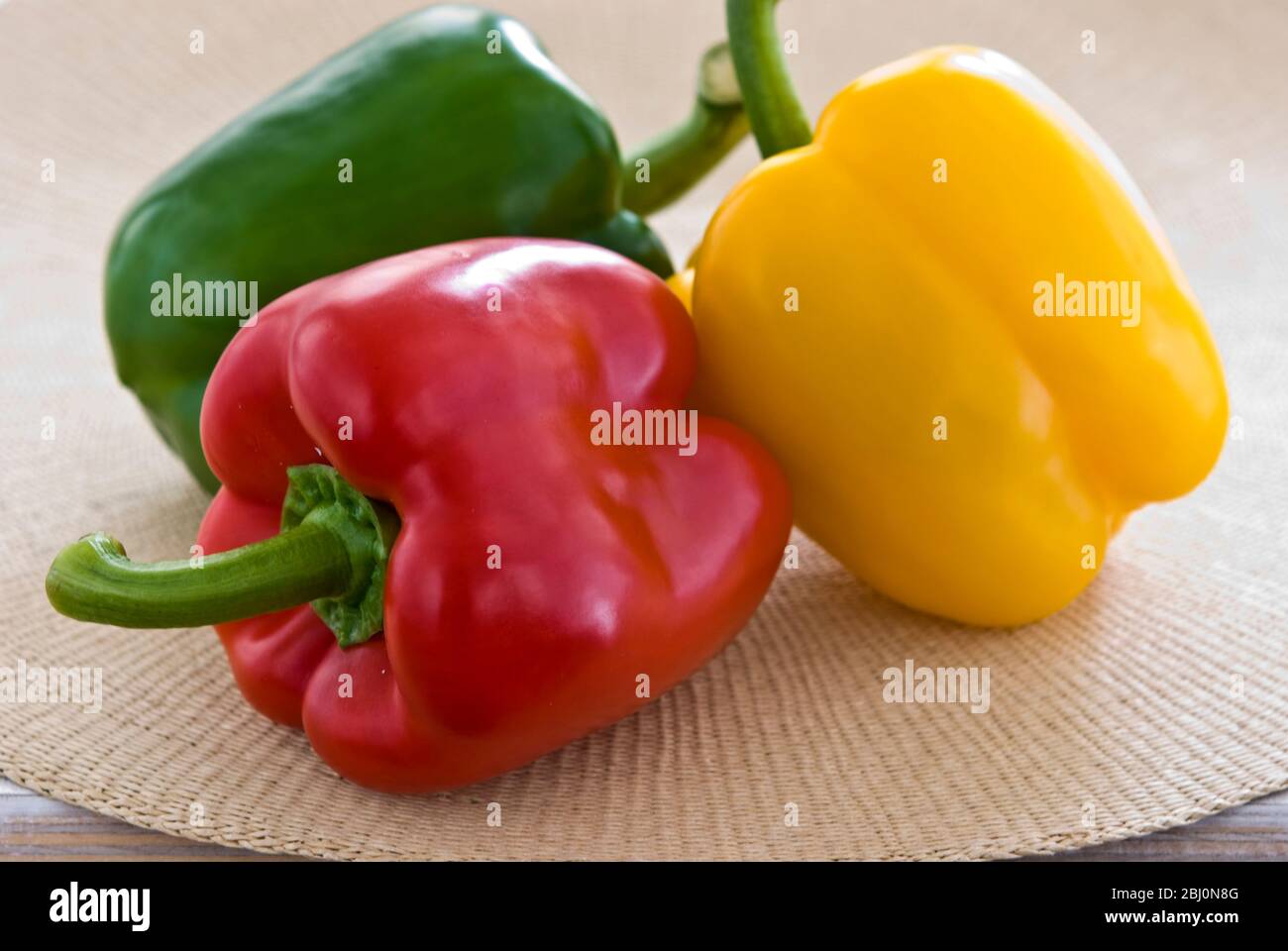 Three shiny sweet peppers, red, green, and yellow - Stock Photo