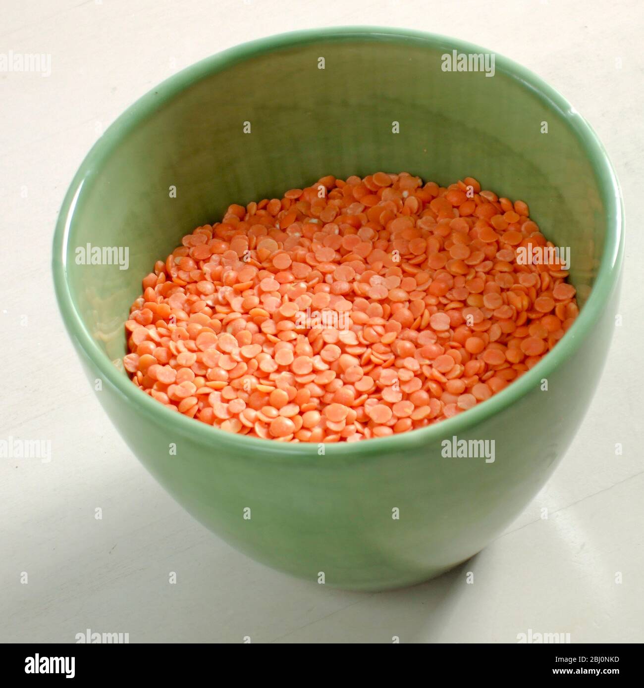 Pottery bowl of raw red split lentils - Stock Photo