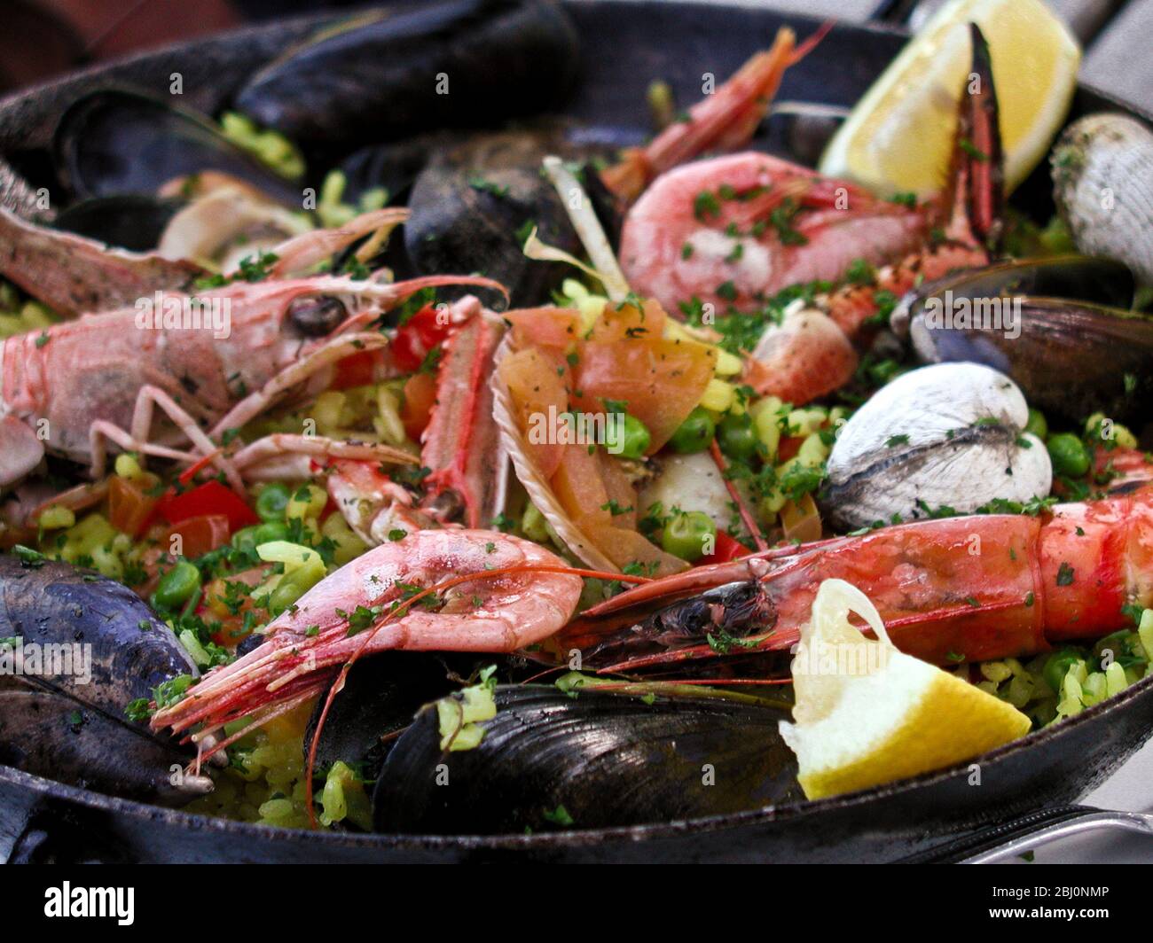 Paella in pan with prawns, shrimp, clams, mussels, - Stock Photo