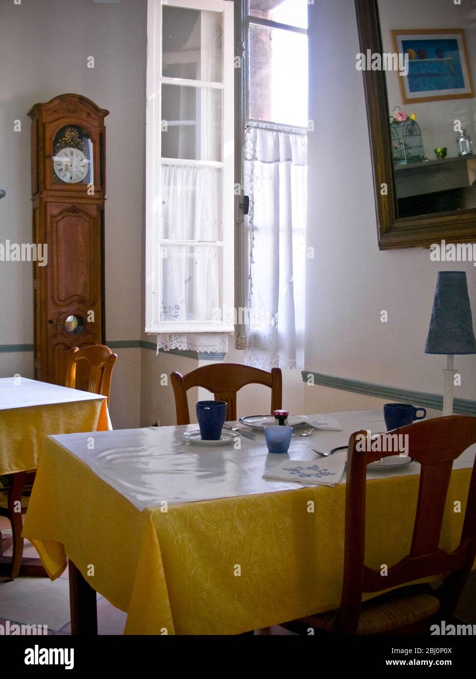 Interior. Dining room of charming hotel in Rieumes, southern France, with tables set for breakfast - Stock Photo