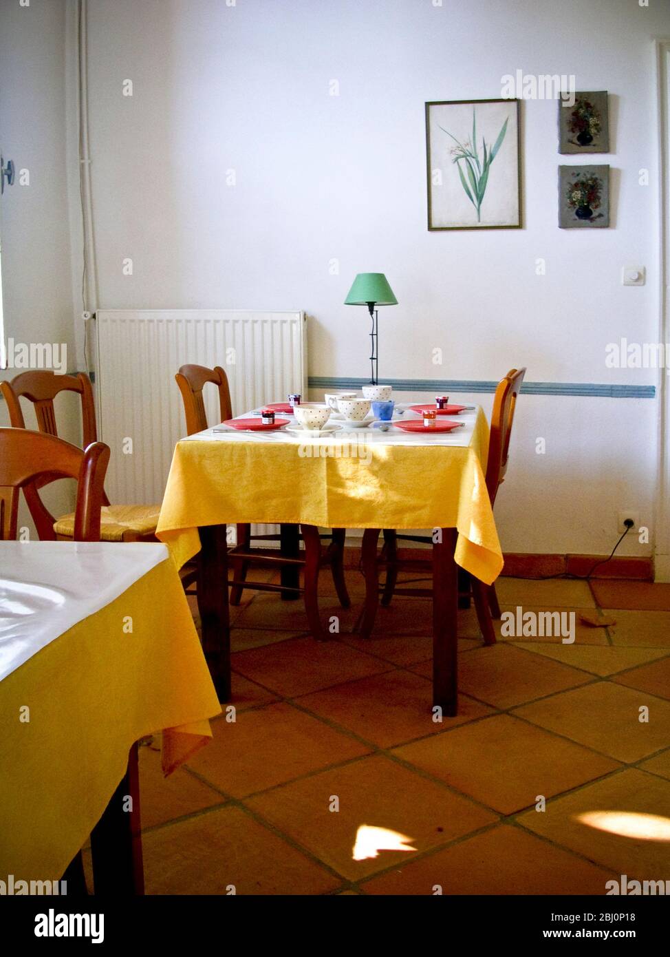 Interior. Dinging room of charming hotel in Rieumes, southern France, with tables set for breakfast - Stock Photo